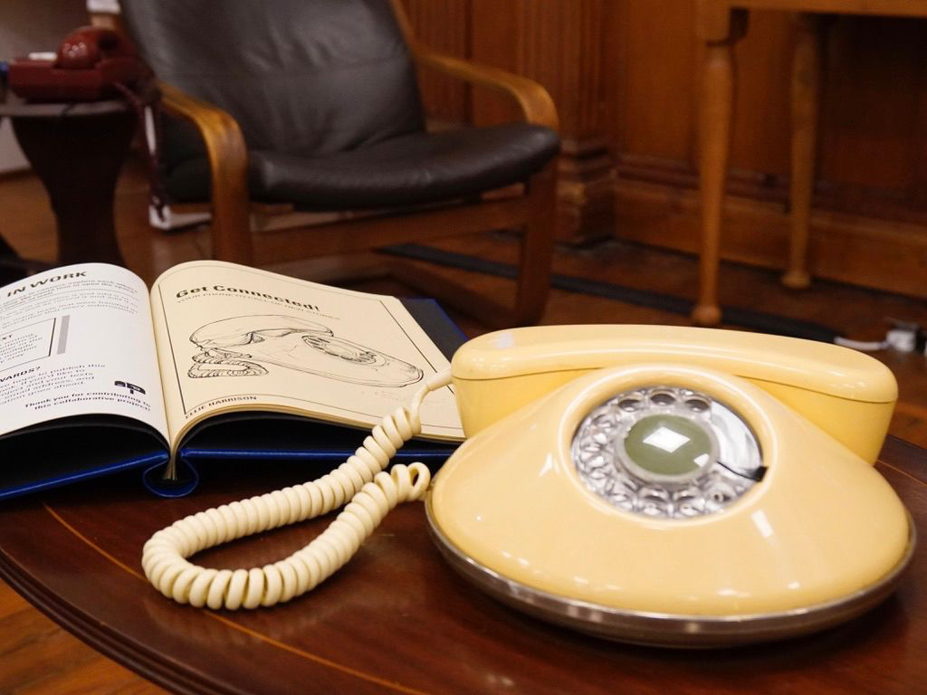 A pancake rotary phone on a table.