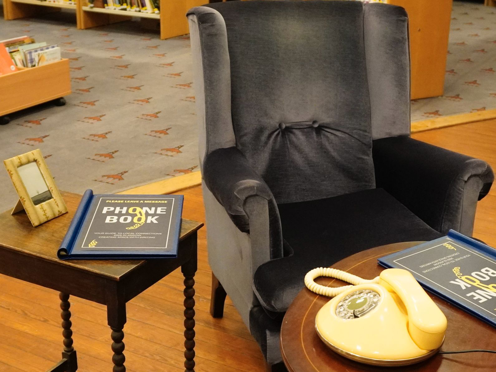 A photo of the pancake phone beside an armchair and phone books.